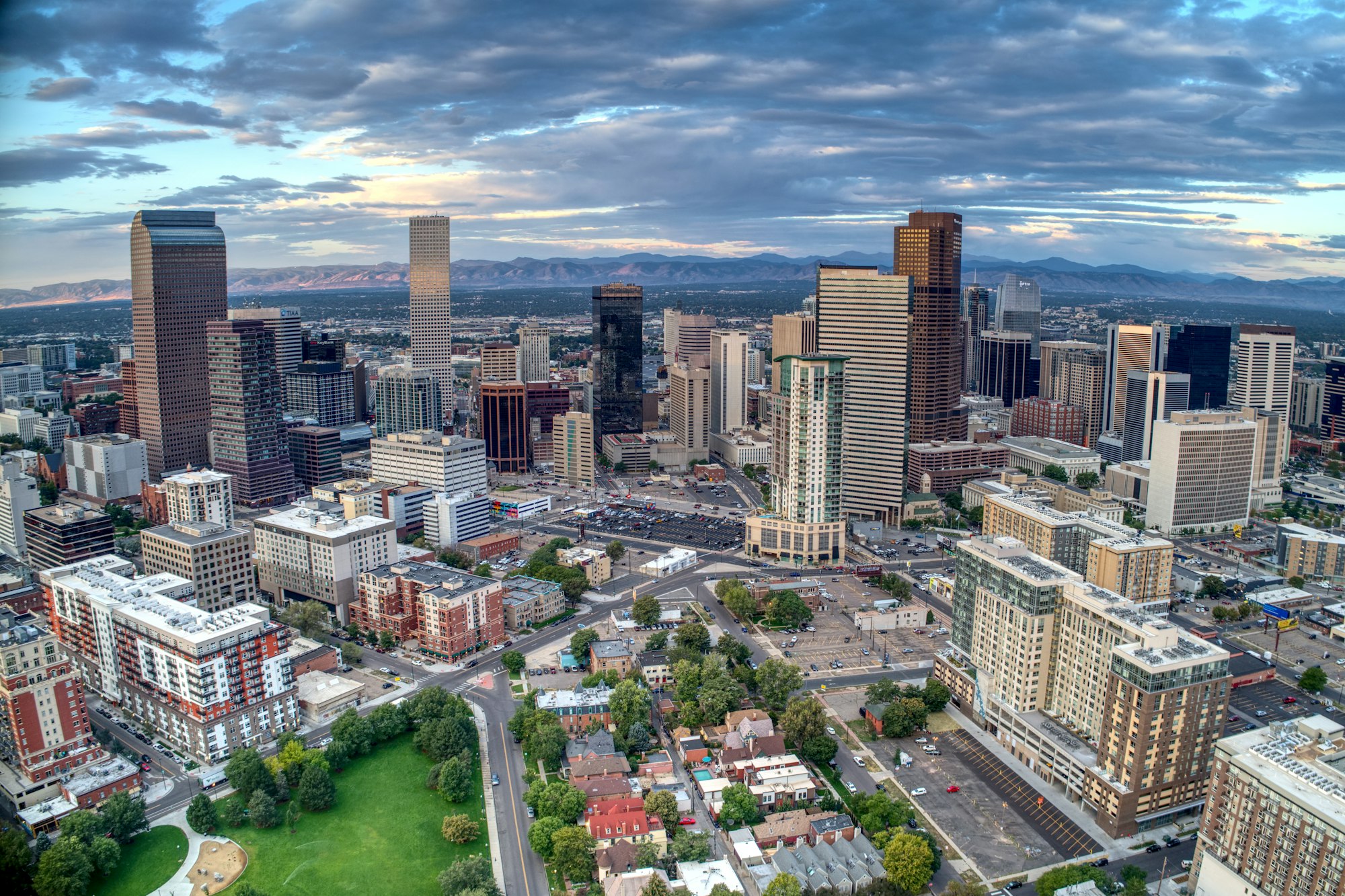 Aerial view of downtown Denver at daybreak with the Rocky Mountains along the western horizon